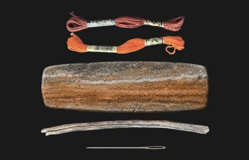 Materials flat-lay — embroidery thread, stone and needle used in a Vertical Works artwork
